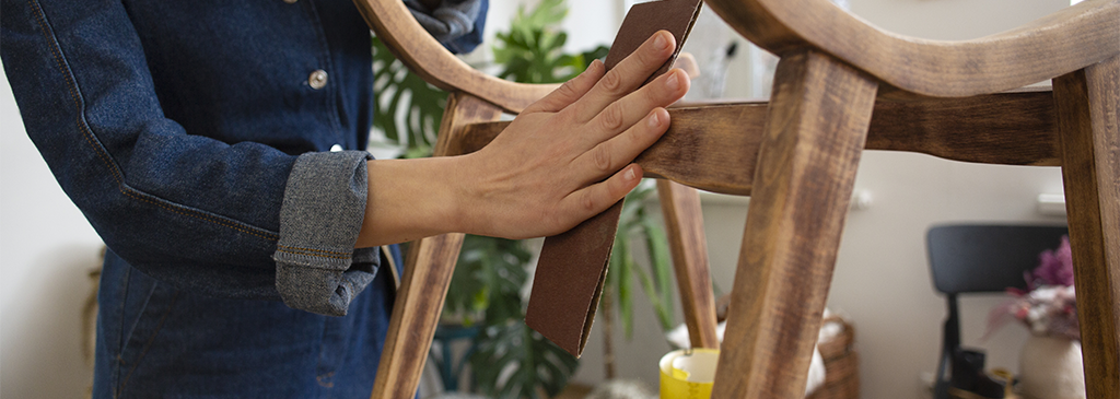 upcycling artistique - personne qui ponce un meuble en bois